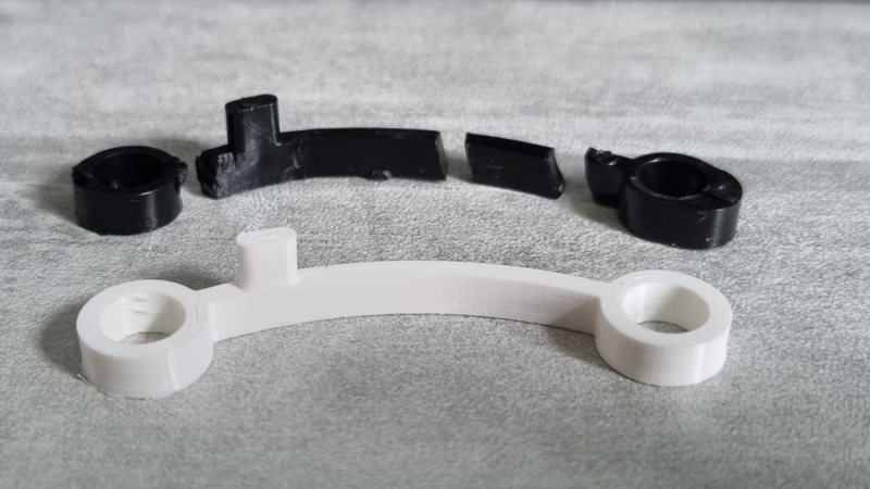 Une pièce de blender cassée en quatre morceaux, et la même pièce réimprimée en blanc, entière.